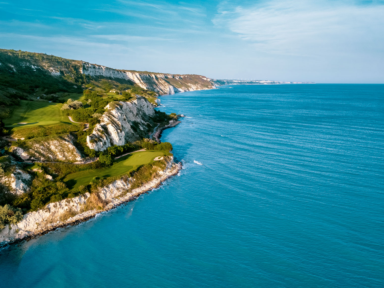 Aerial view of the signature 6th hole at Thracian Cliffs, a Gary Player-designed golf course on white cliffs above the Black Sea, Bulgaria